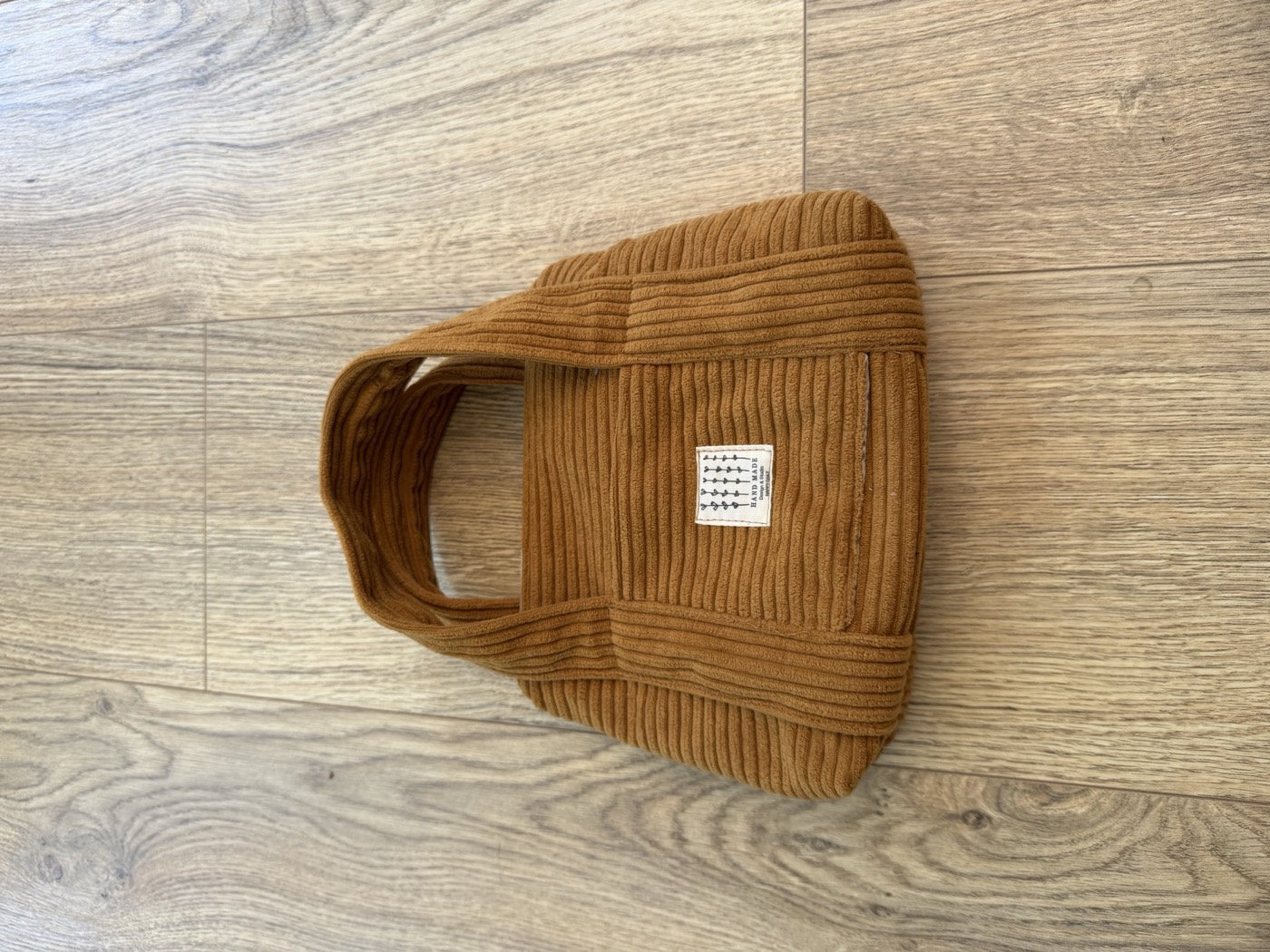 Petit sac à main en velours côtelé camel, vue de face avec l'étiquette Hand Made