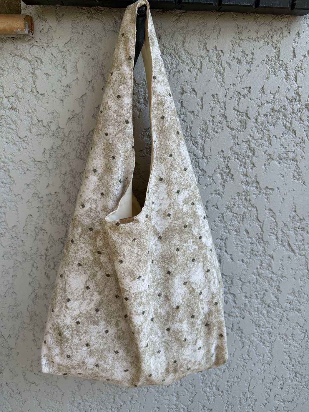 Le même sac hobo vu de trois quarts, doublure écrue visible à l'ouverture